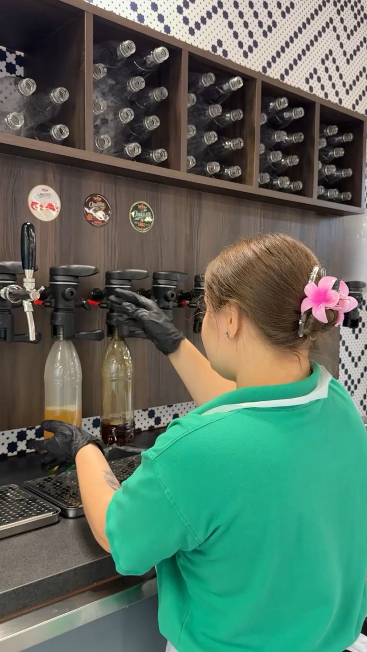 Een medewerker vult een fles bij onze bier- en kvastap.